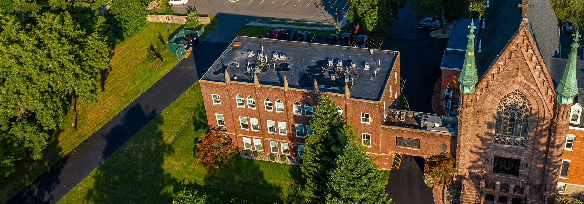 Aerial view of brick building beside stone church
